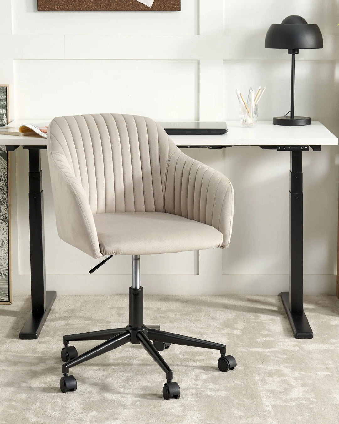 Beige office chair in front of a white desk with a black lamp.
