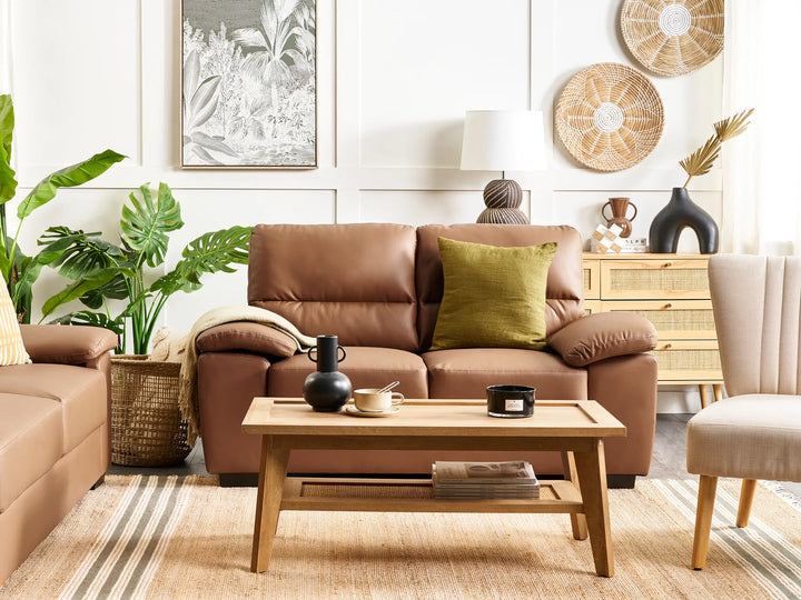 Living room with brown leather sofa, wooden coffee table, and decorative items.