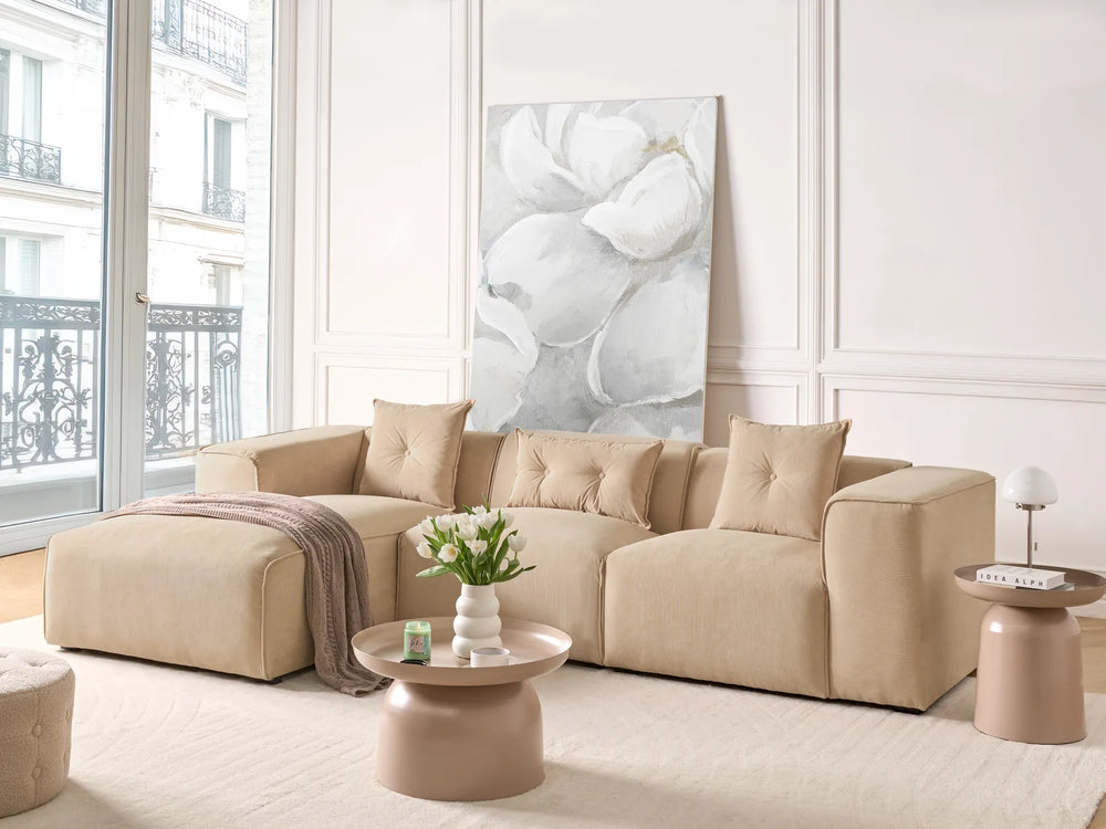 Beige sectional sofa in a living room with a large abstract painting on the wall.