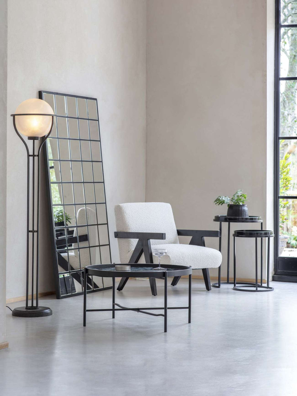 Modern interior with a white armchair, black floor lamp, and side table.