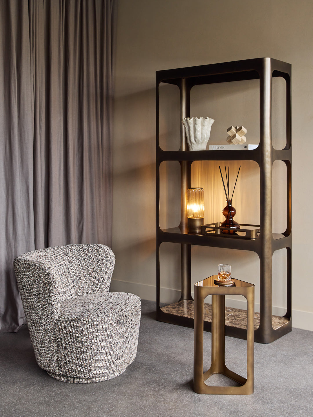 Modern interior with a textured chair, wooden side table, and decorative shelf.