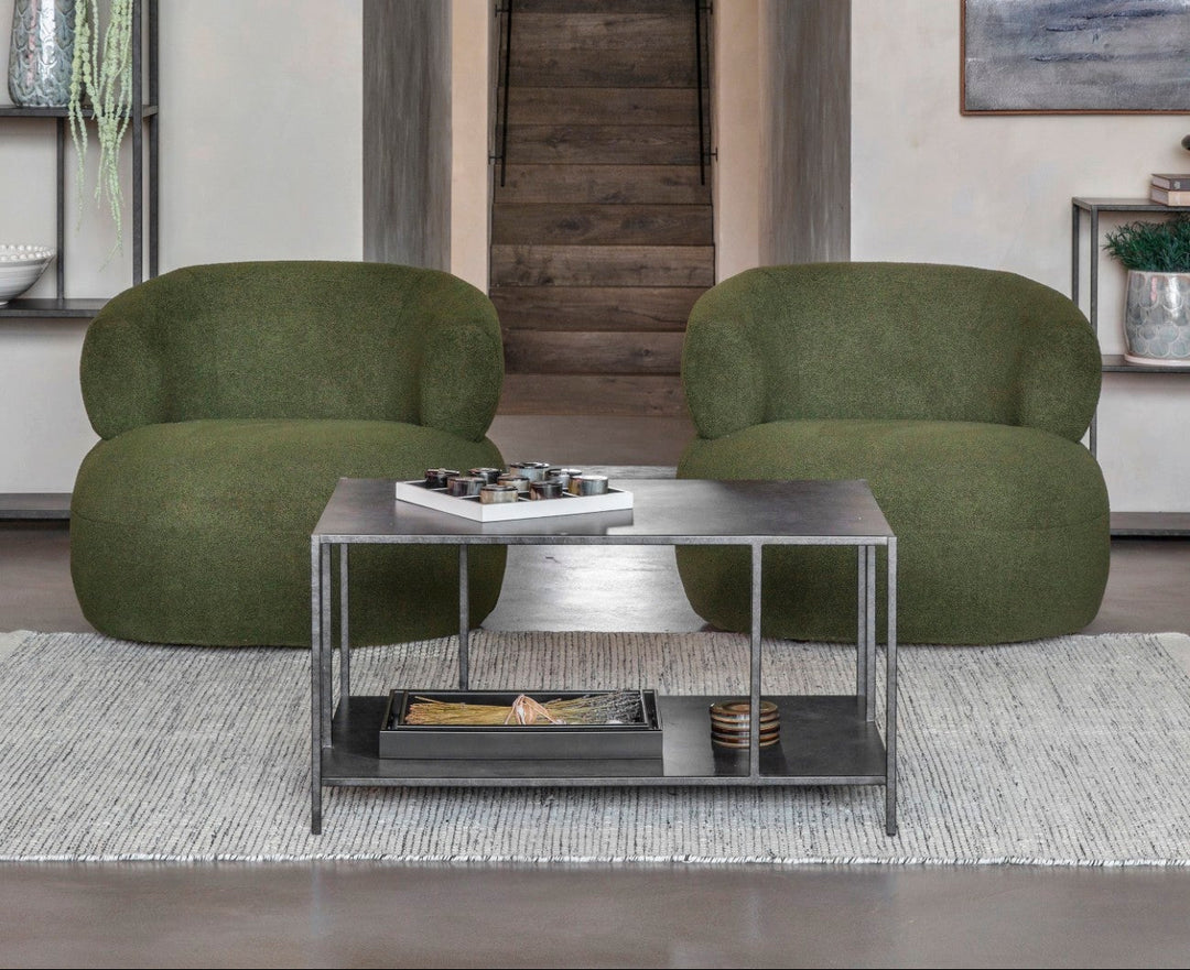 Modern living room with green armchairs and a coffee table.