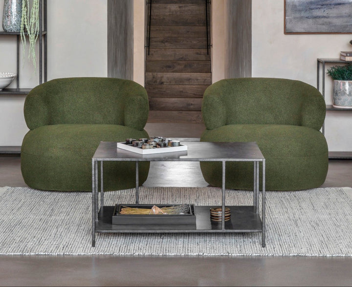 Modern living room with green armchairs and a coffee table.