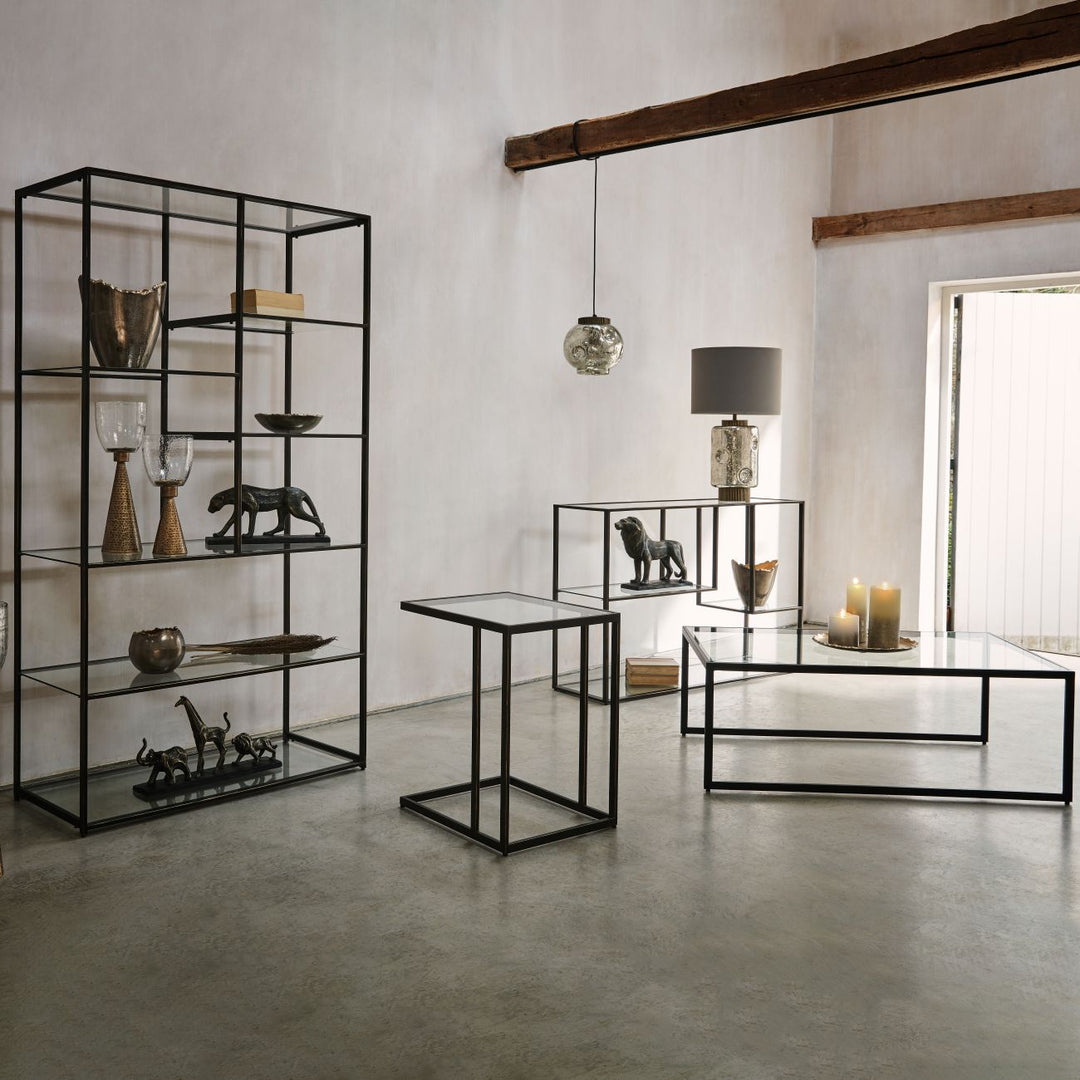 Modern interior with black metal shelves and tables against a white wall.