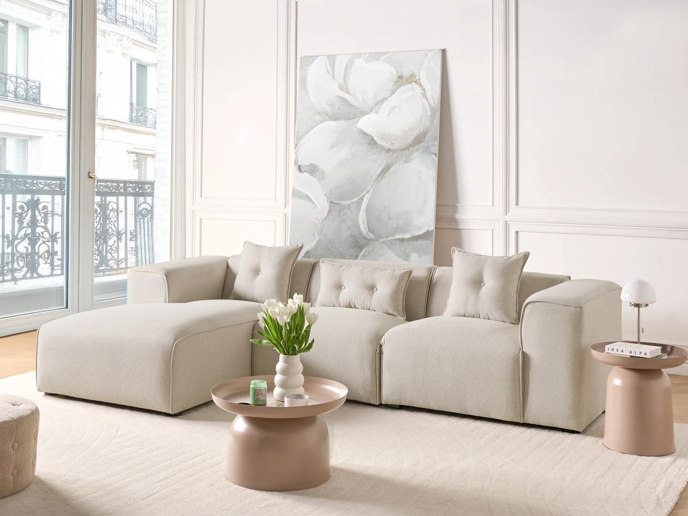 Modern living room with a beige sofa, coffee table, and decorative wall art.
