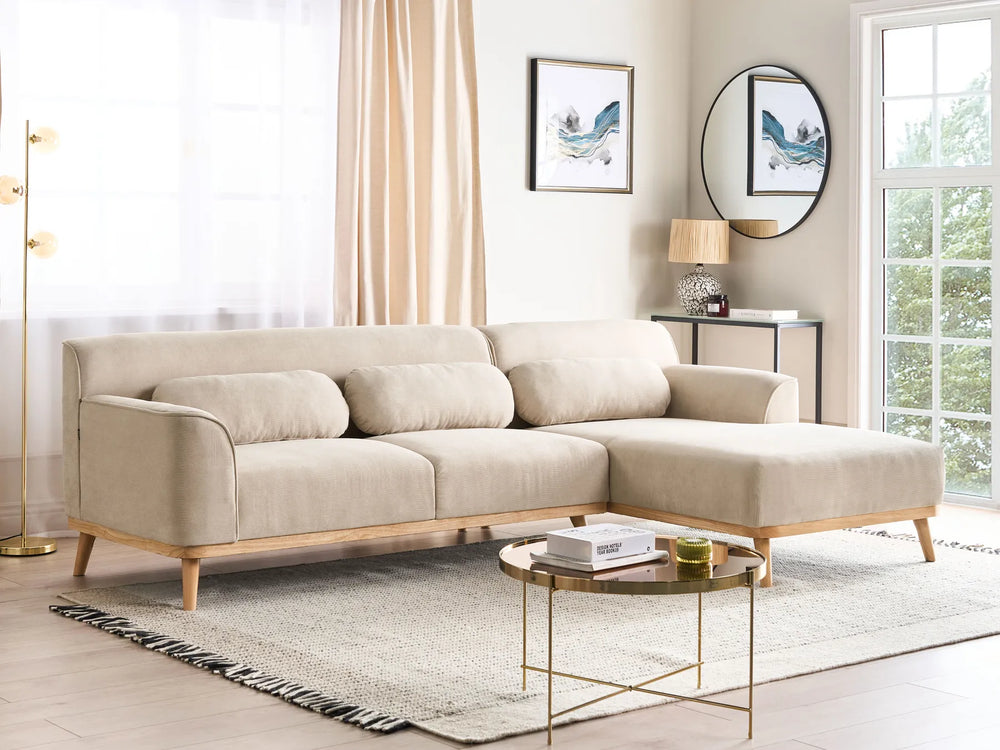 Beige sectional sofa in a living room with a coffee table and decor.