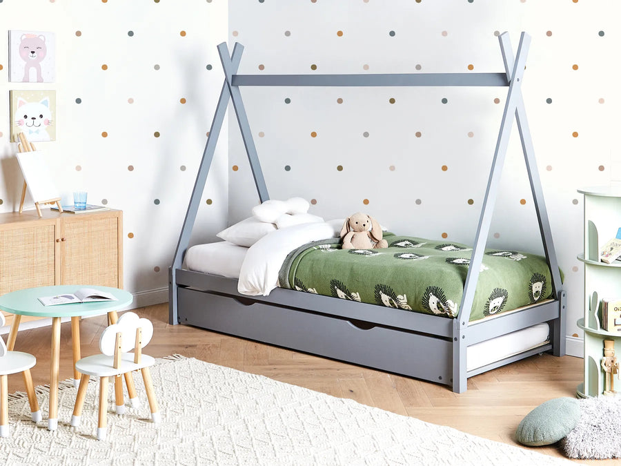 Children's room with a teepee-style bed, table, chairs, and toys.