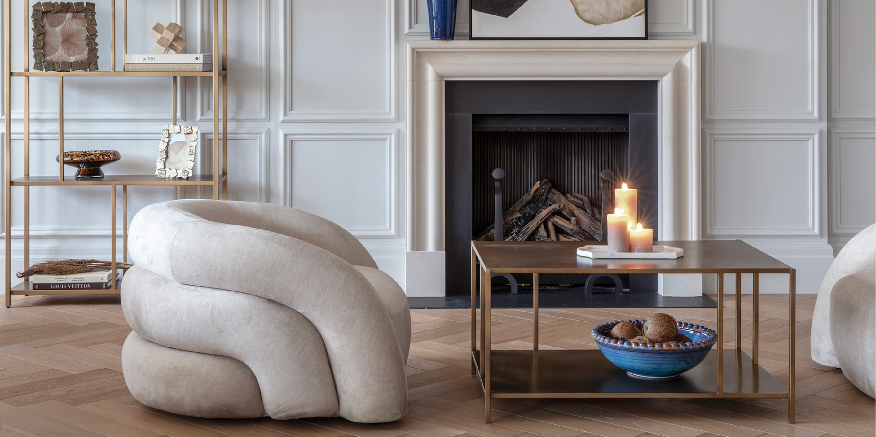 Modern living room with a curved beige armchair, coffee table, and fireplace.