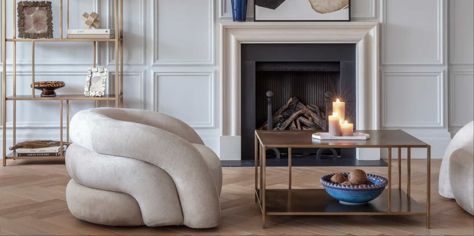 Modern living room with a curved beige sofa, wooden coffee table, and fireplace.