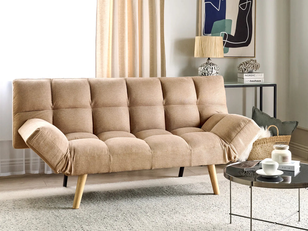 Beige sofa in a living room setting with a coffee table and decor items.