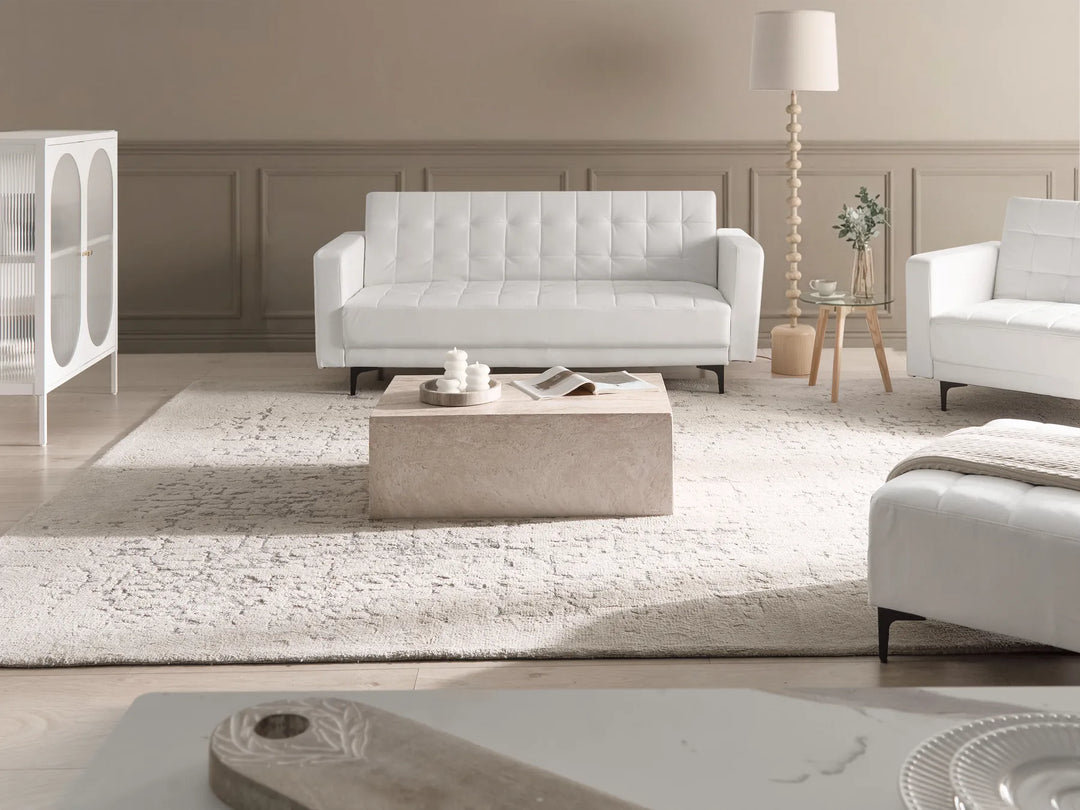 Modern living room with white sofas, a coffee table, and decorative items.