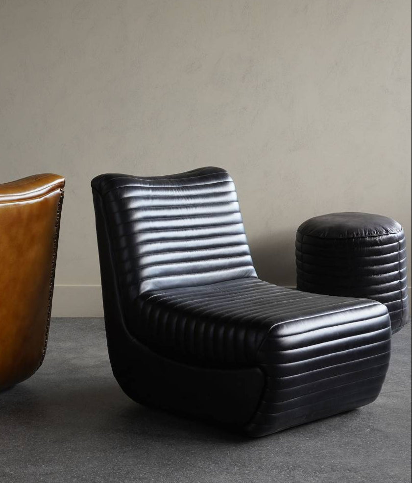 Three modern chairs in brown, black, and striped design against a plain wall.