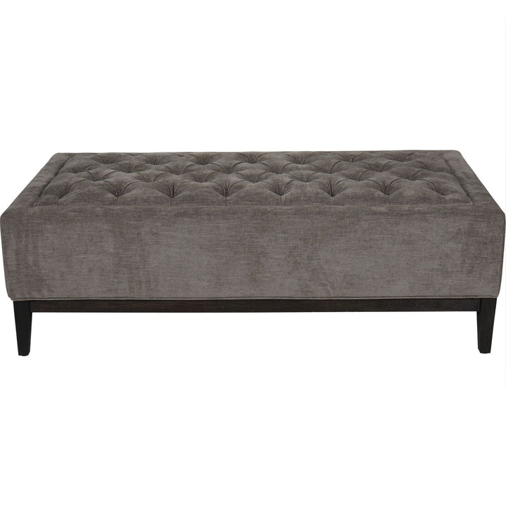 Gray tufted sofa in a room with a white background.