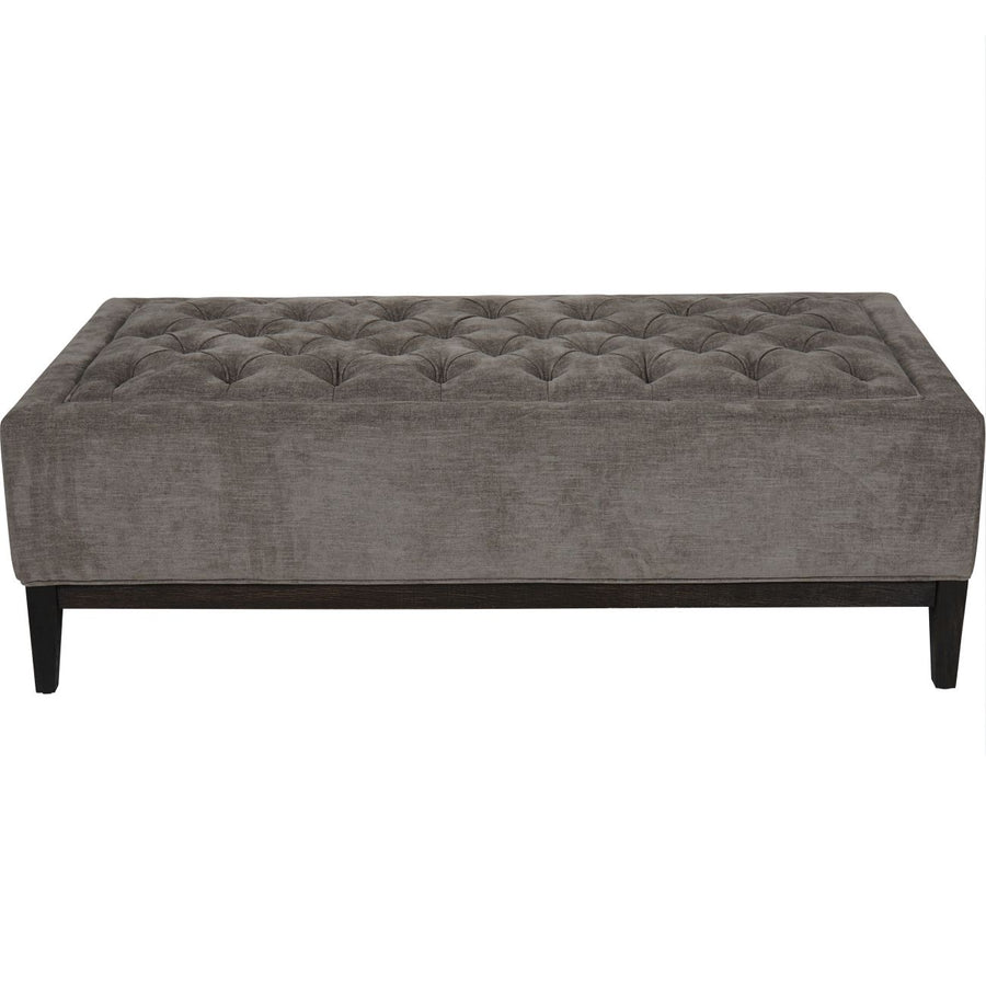 Gray tufted sofa in a room with a white background.
