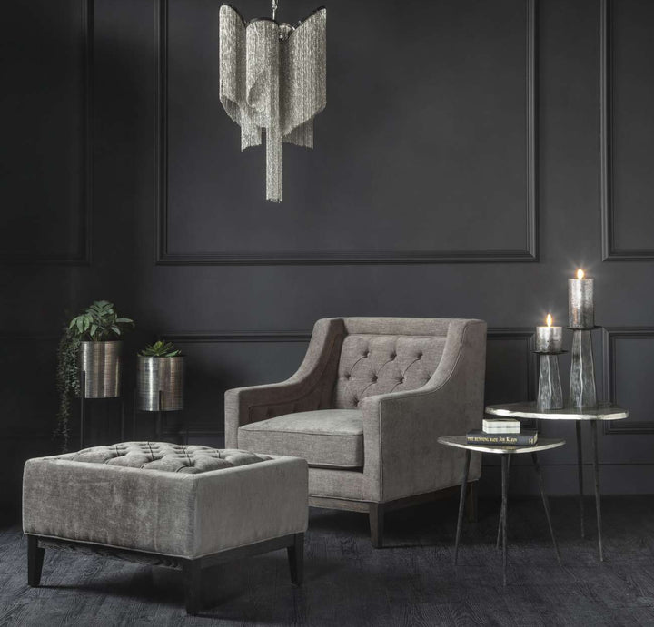 Gray upholstered armchair with tufted backrest on a white background