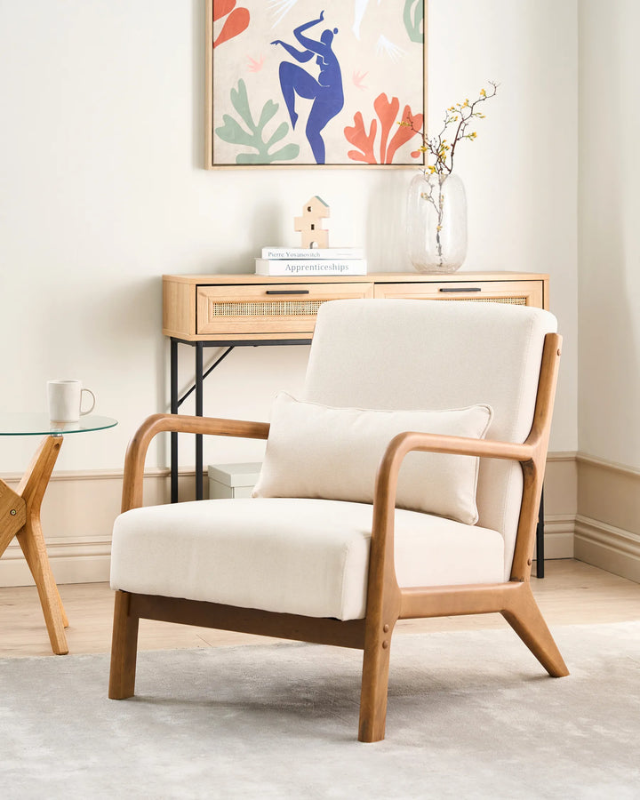 White armchair with wooden frame in a room with a small table and decorative wall art.