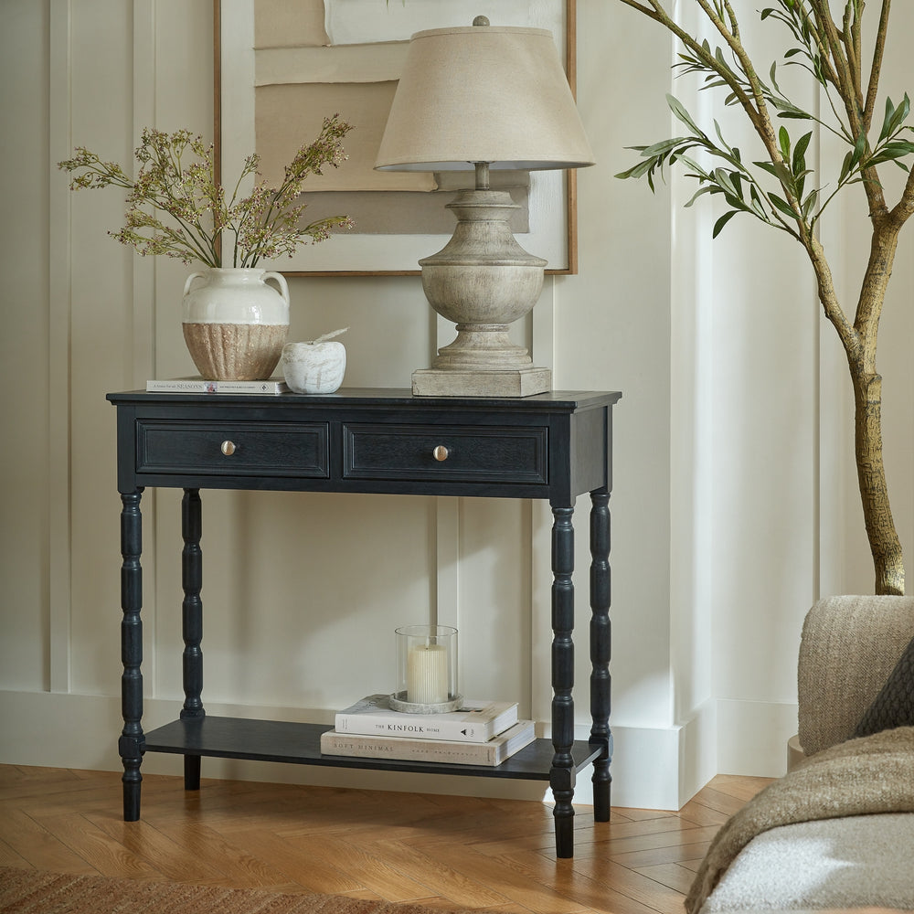 Black console table with decorative items in a living room setting