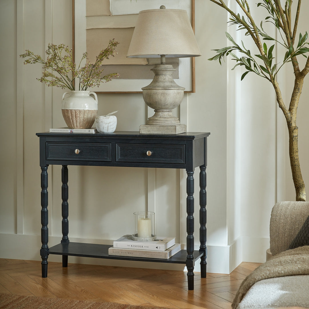 Black console table with decorative items in a living room setting