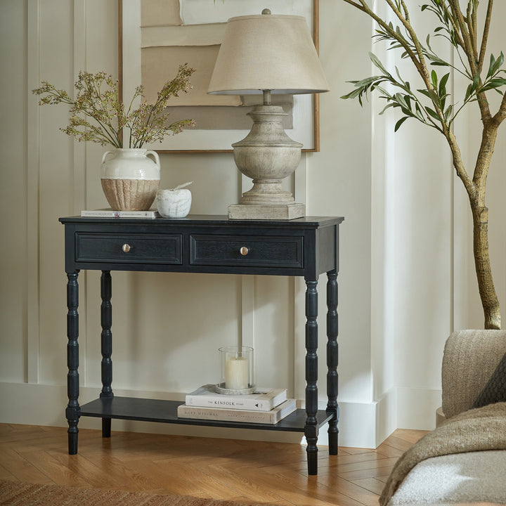 Black console table with decorative items in a living room setting