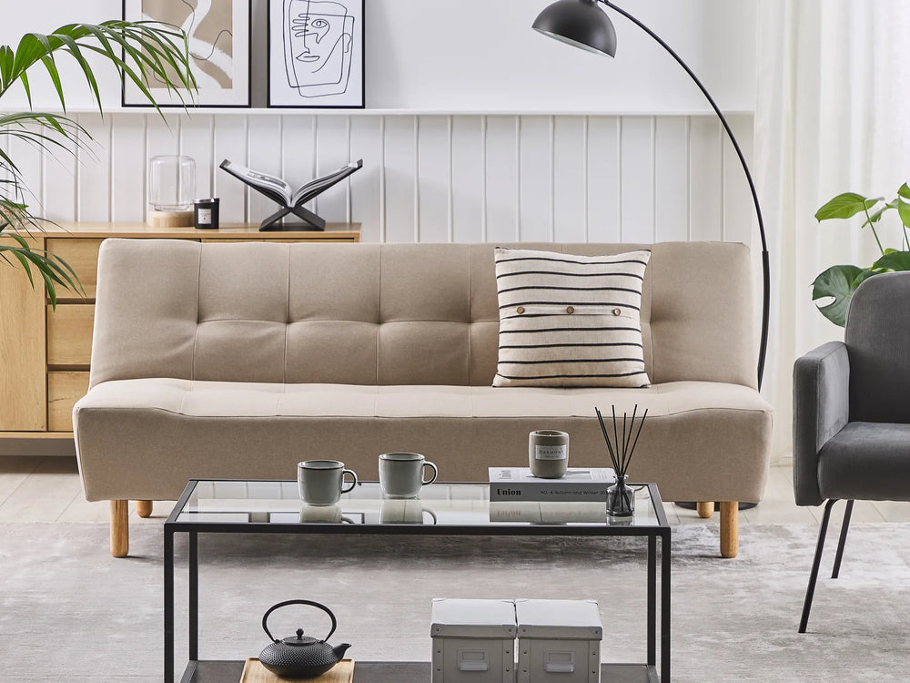 Beige sofa with a striped pillow in a modern living room setting.