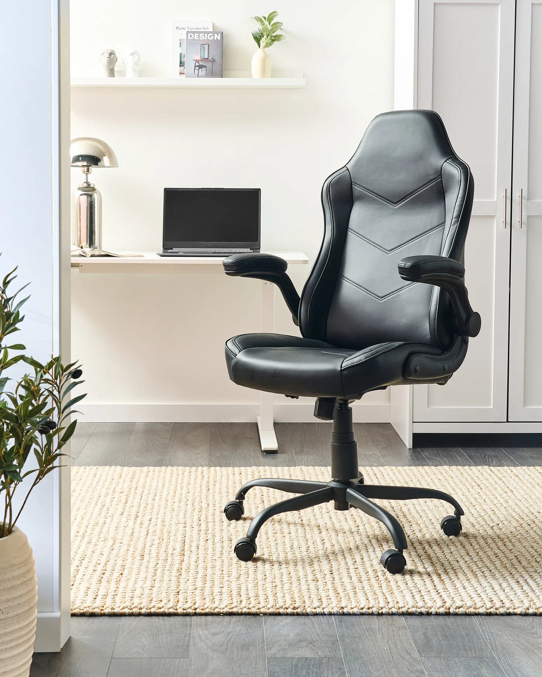 Black office chair in a home office setting with a desk and laptop.