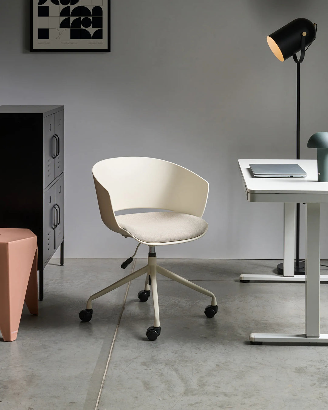 Modern office chair in a minimalistic office setting with a desk and lamp.