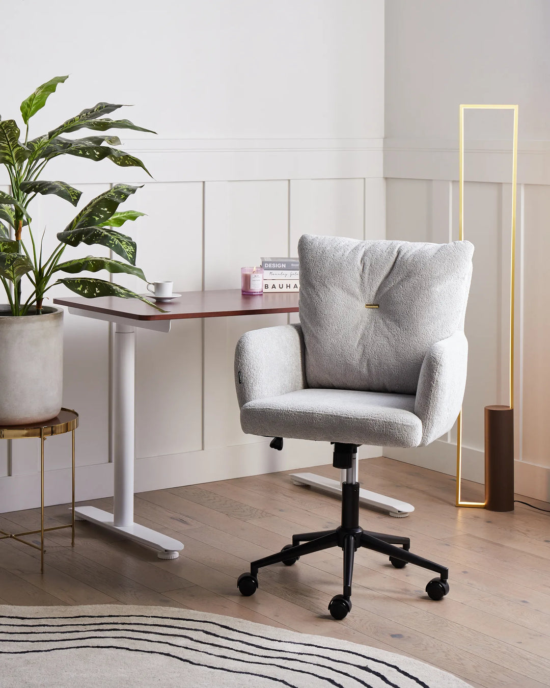 Gray office chair in a modern office setting with a desk and plant.