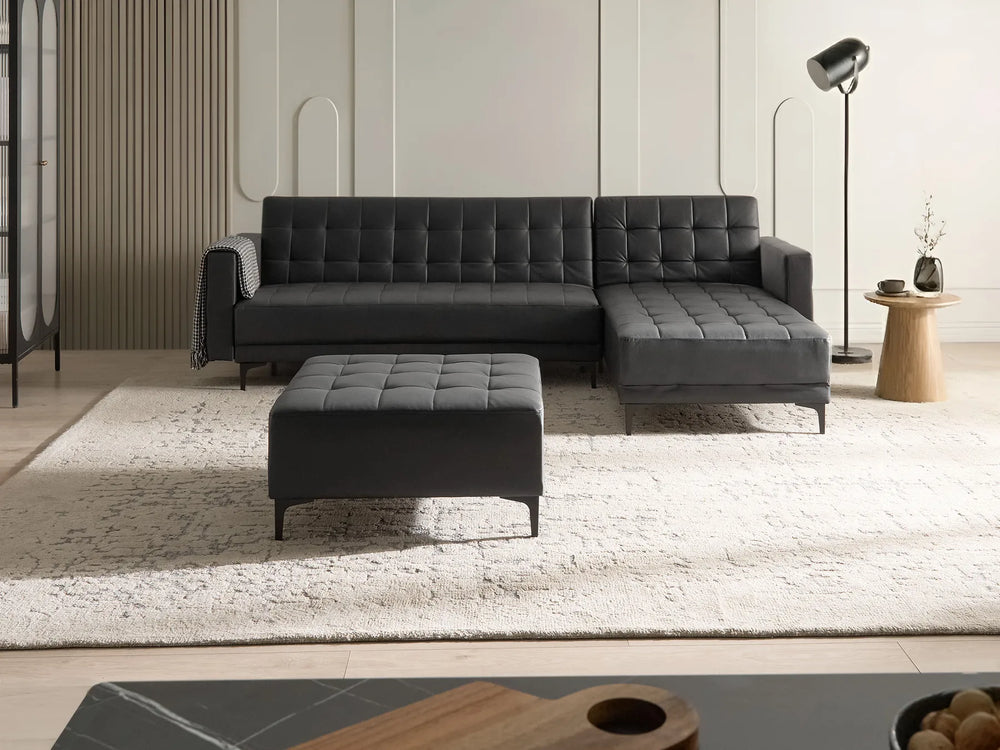 Black faux leather corner sofa with ottoman, left-hand layout