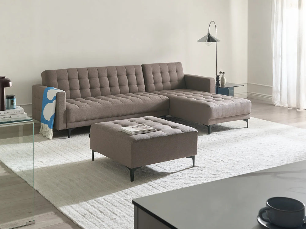 Modern living room with a brown sectional sofa and ottoman.