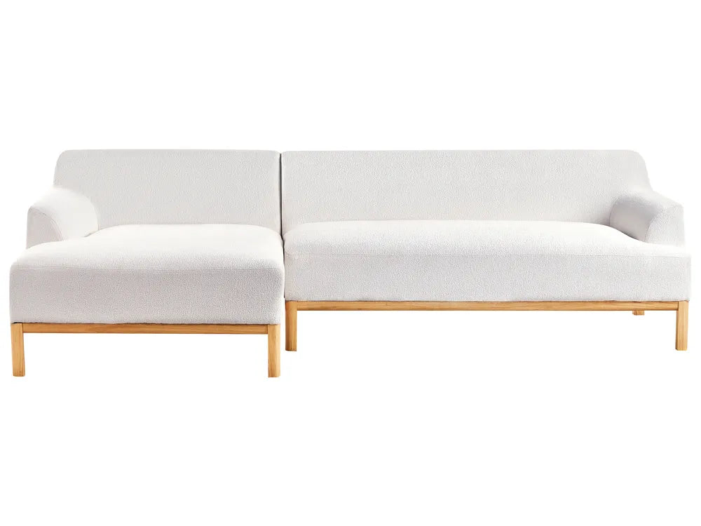 White sectional sofa with wooden legs on a white background