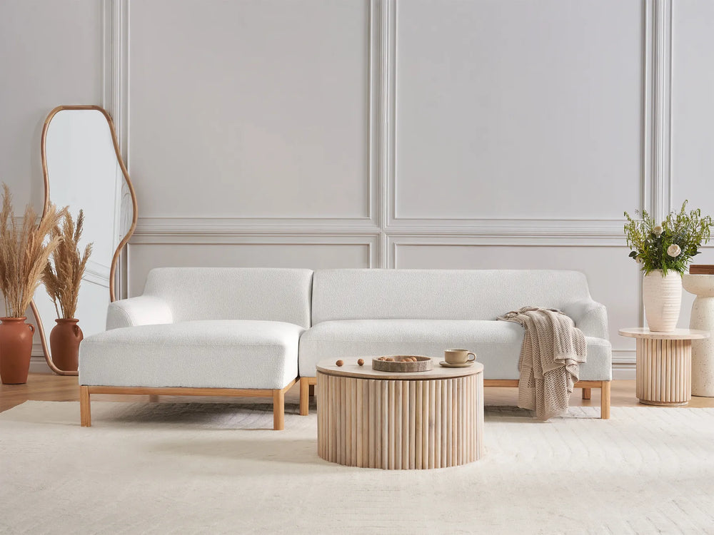 Modern living room with a white sofa, wooden coffee table, and decorative elements.