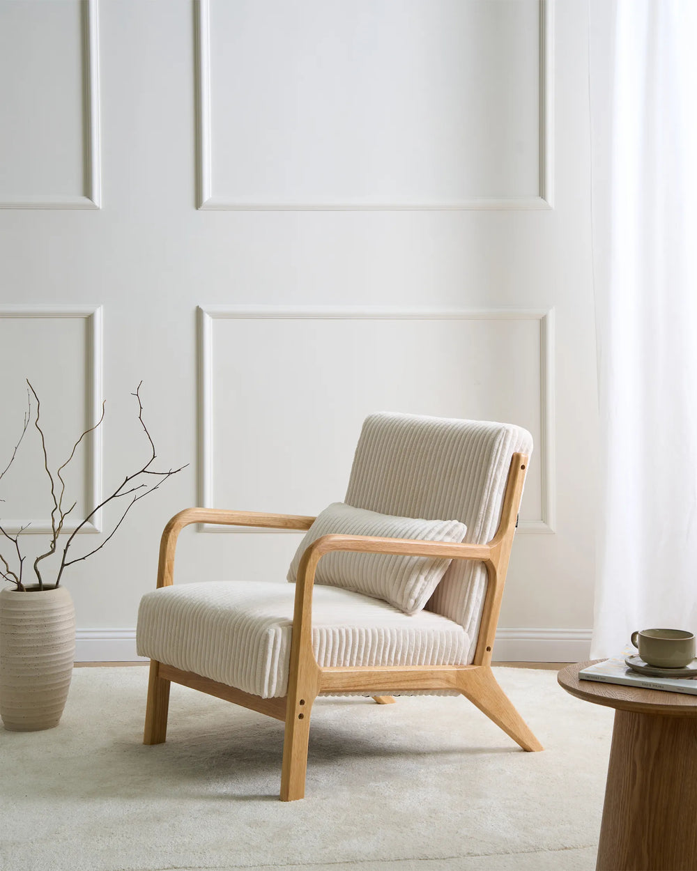 Modern armchair in a minimalistic room with a light-colored wall and a small table.