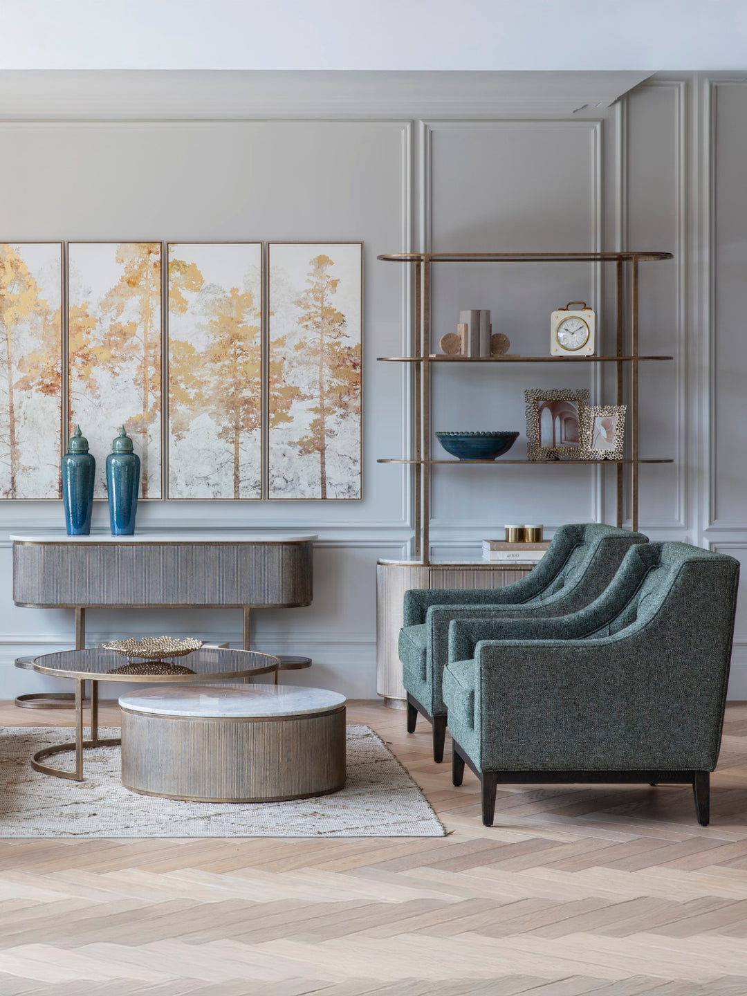 Modern living room with gray chairs, round coffee table, and decorative wall art.