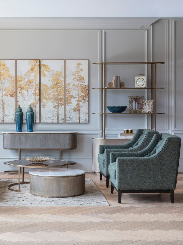 Modern living room with gray chairs, round coffee table, and decorative wall art.