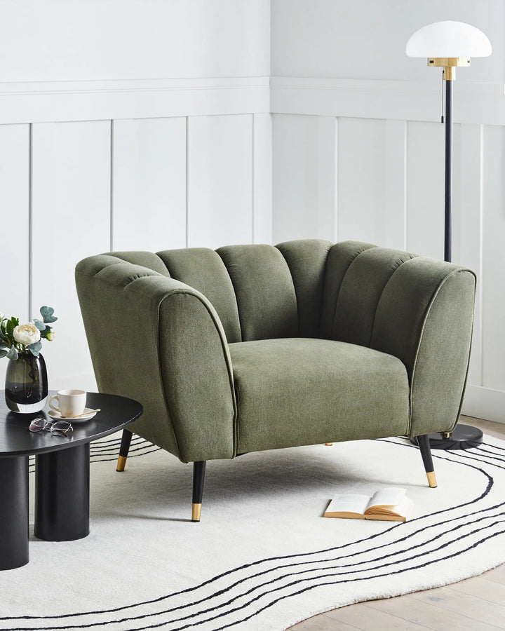 Green sofa in a modern living room with a white wall and black coffee table.