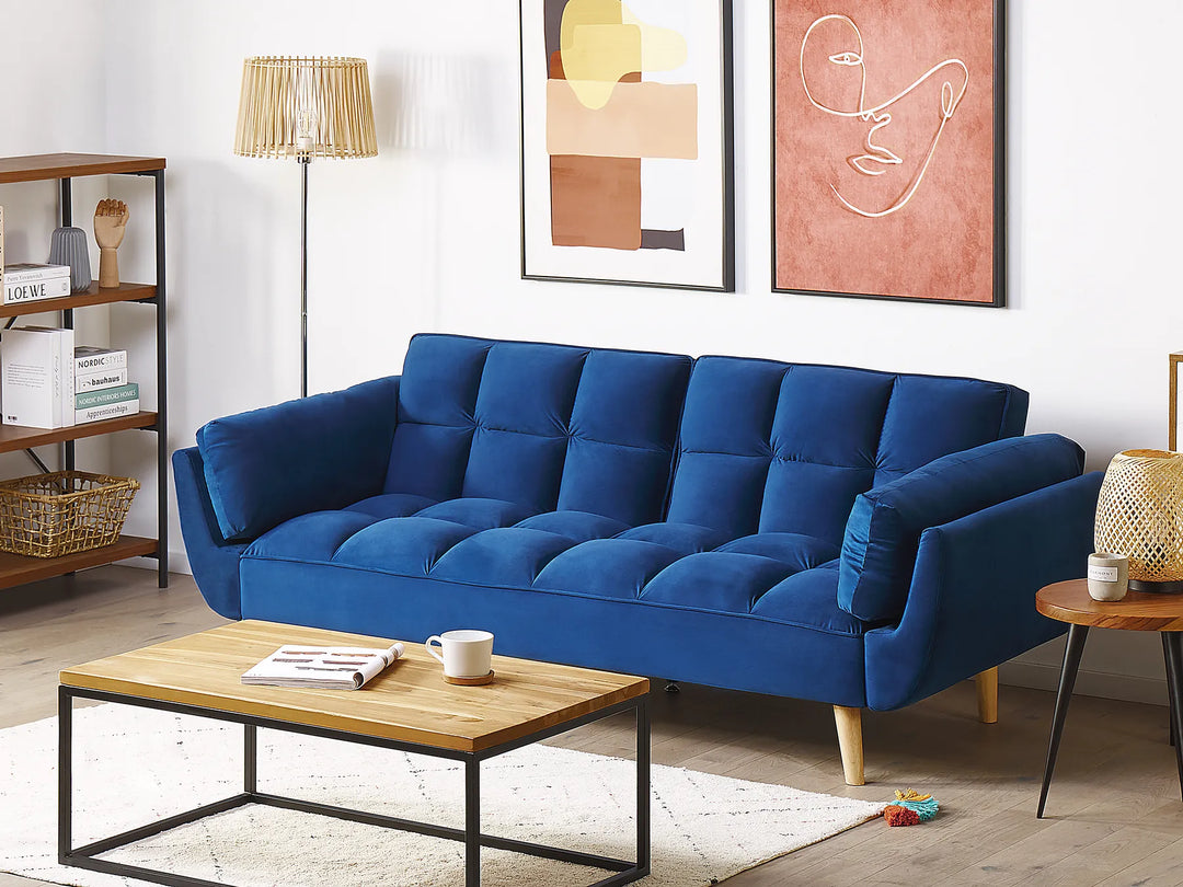 Blue sofa in a living room with a wooden coffee table and decorative items.