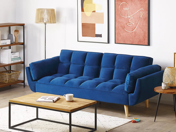 Blue sofa in a living room with a wooden coffee table and decorative items.