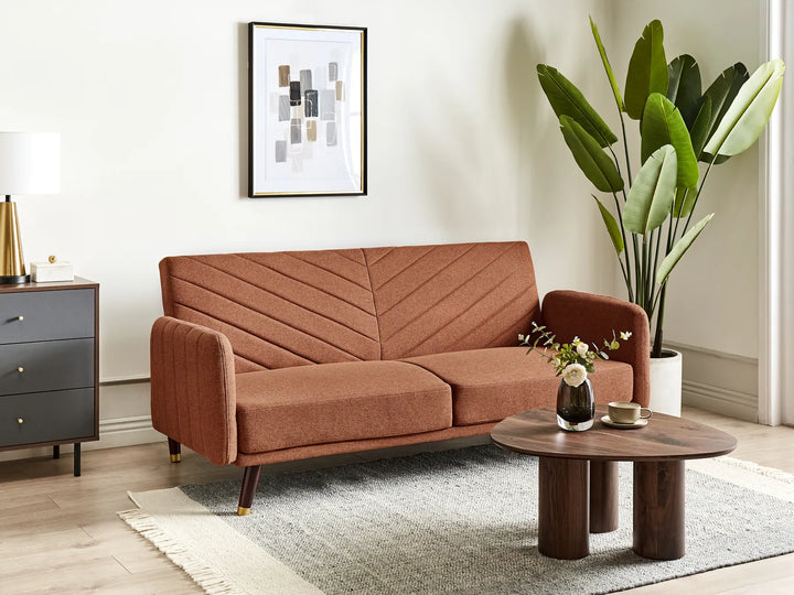 Brown sofa in a living room with a coffee table and decorative items.