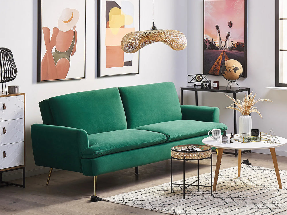 Modern living room with a green sofa, coffee table, and decorative items.