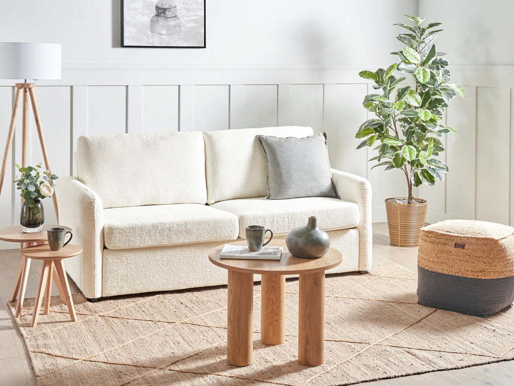 Modern living room with a white sofa, wooden coffee table, and decorative items.