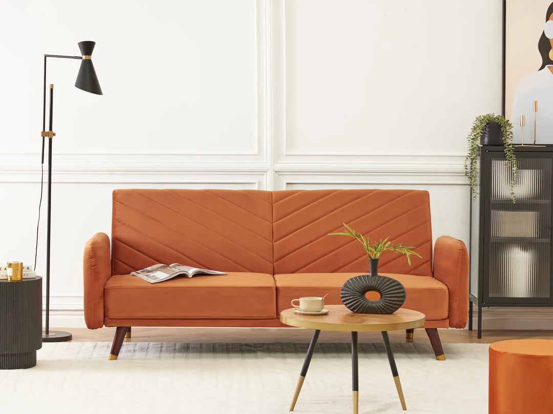 Orange sofa in a living room setting with a coffee table and decorative items.