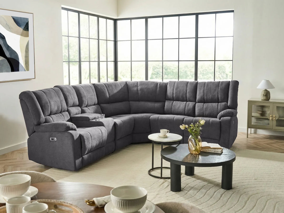 Gray sectional sofa in a living room with large windows and decorative items.