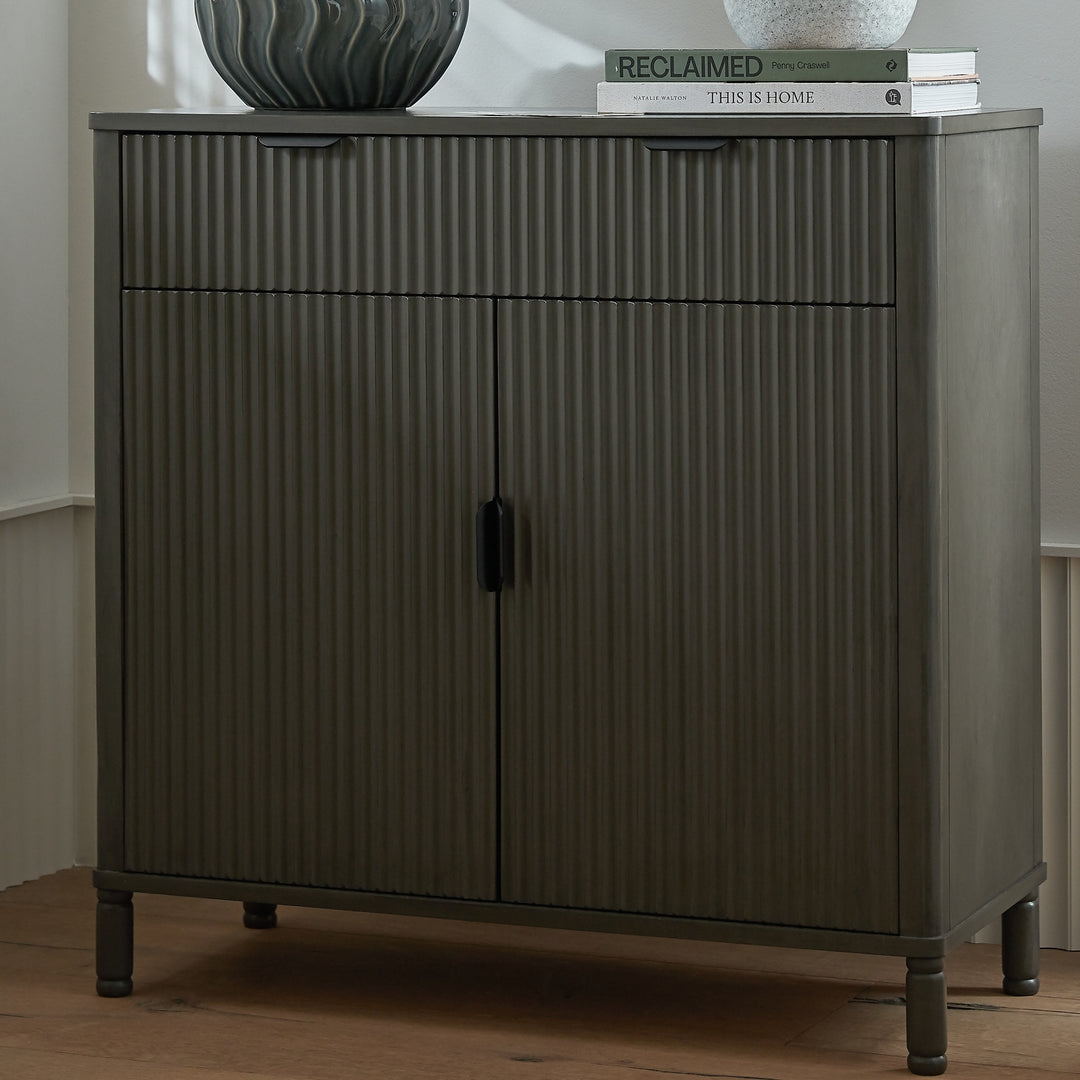 Dark wooden cabinet with ribbed texture on a wooden floor.