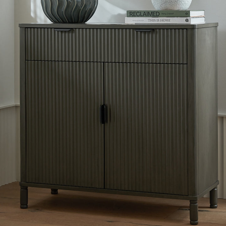 Dark wooden cabinet with ribbed texture on a wooden floor.