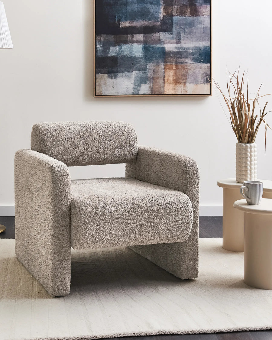 Textured armchair in a living room setting with abstract art and decor.