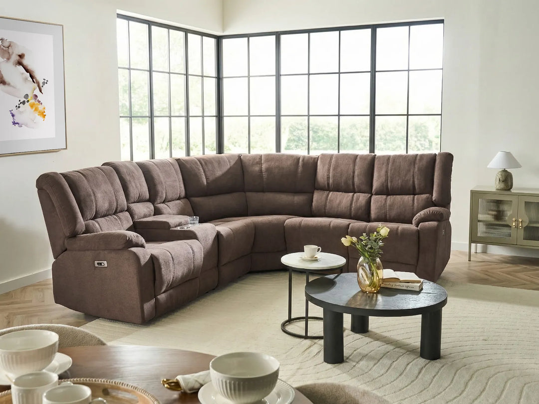 Brown sectional sofa in a living room with a coffee table and decor items.