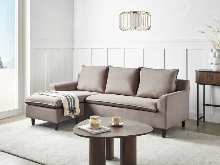 Gray sectional sofa in a modern living room with a coffee table and decorative items.