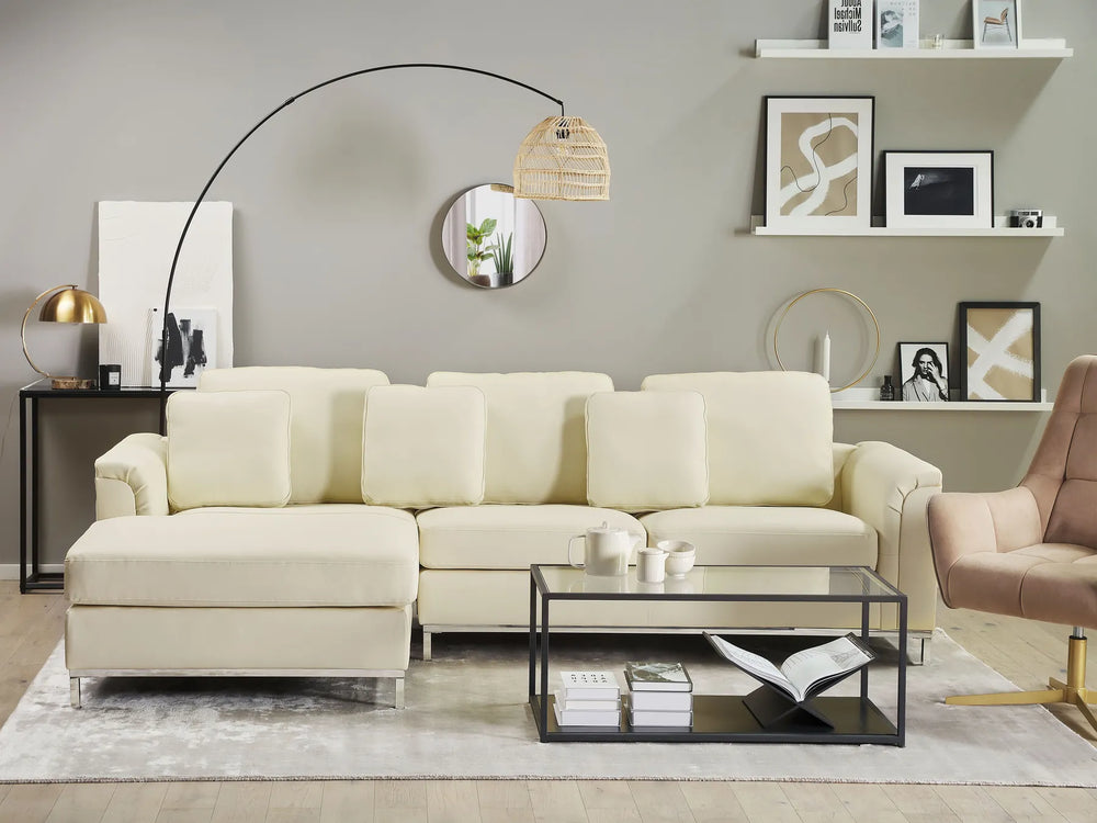 Modern living room with a beige sectional sofa, coffee table, and decorative items.