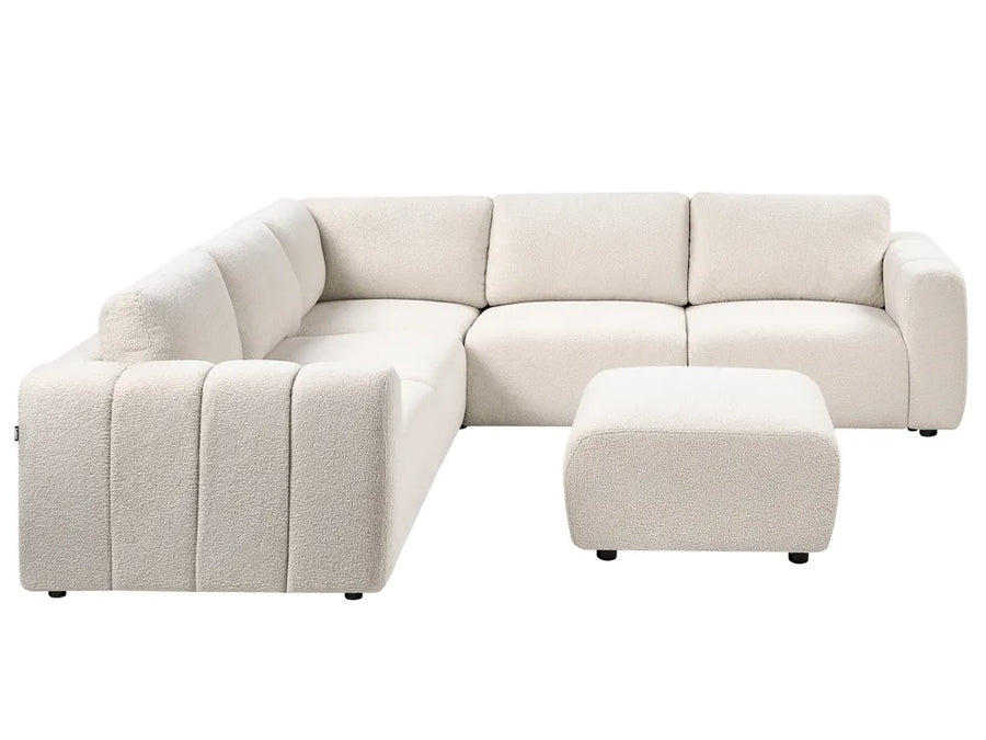 Beige sectional sofa with ottoman on a white background