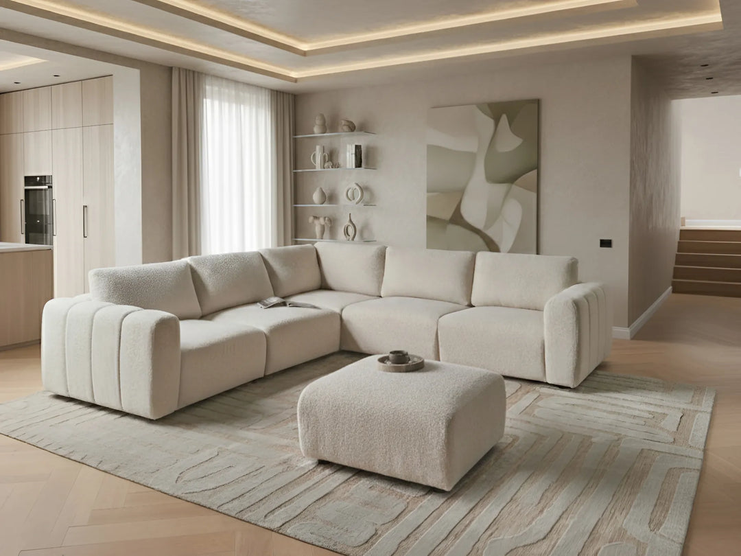 Modern living room with a beige sectional sofa and ottoman.